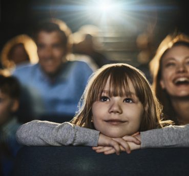 Close up of a young family enjoying a movie in the cinema